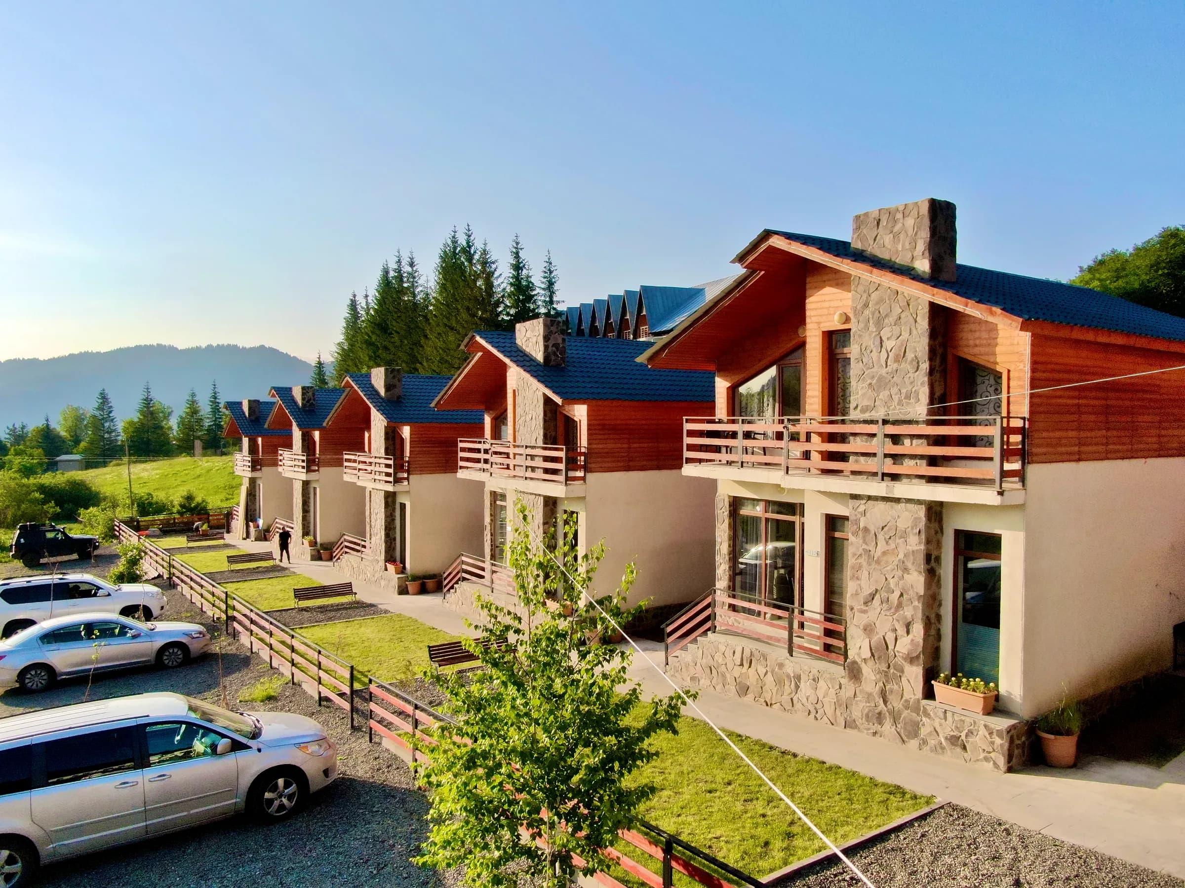 Bright summer villa exterior in Bakuriani with green mountain surroundings